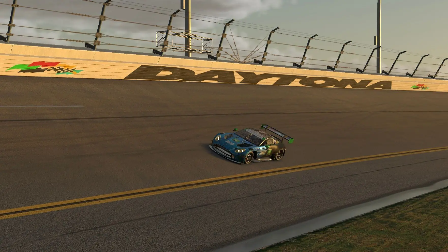 The number 360 Aston Martin Vantage GT3 running the Daytona banking below the trackside lettering